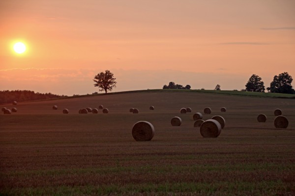 Setting Sun And Hay Bales by Deb Oppermann